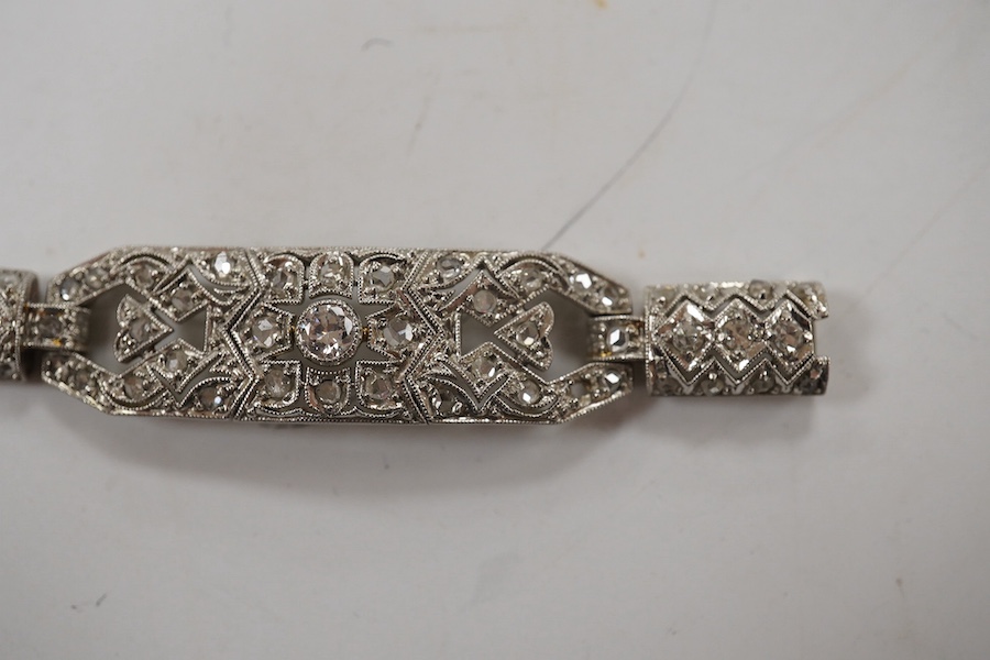 An early 20th century pierced white gold and millegrain set diamond cluster bracelet, set with round and rose cut stones, 18.1cm, gross weight 18.1 grams. Condition - fair to good